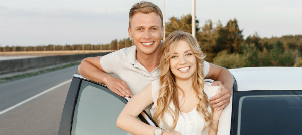 cute couple beside their white car