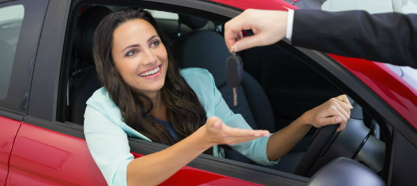 excited woman receives her new car keys