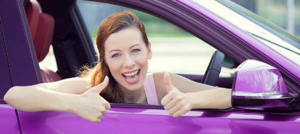 happy woman making a thumbs up while inside her car