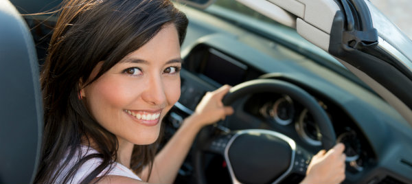 beautiful woman smiling and posing inside her new car