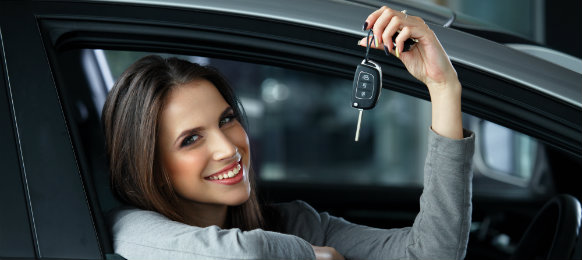 woman smiling and holding her car rental key