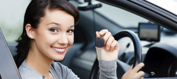 young woman showing keys of her carhire